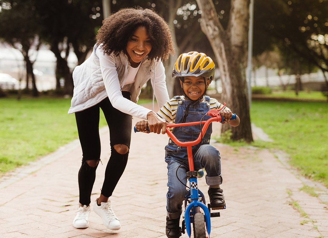 Employee Benefits - Mother Teaching Son to Ride Bicycle at a Park